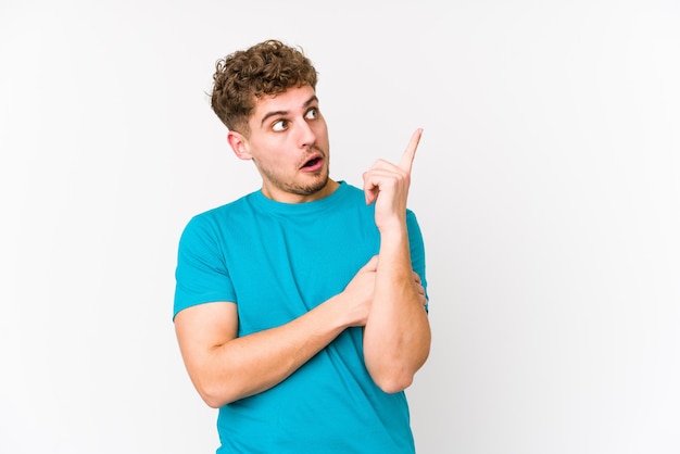 O homem caucasiano do cabelo encaracolado louro novo isolou-se tendo alguma grande ideia, conceito da faculdade criadora.