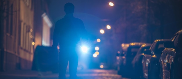 O homem com uma lanterna inspeciona a rua Noite noturna