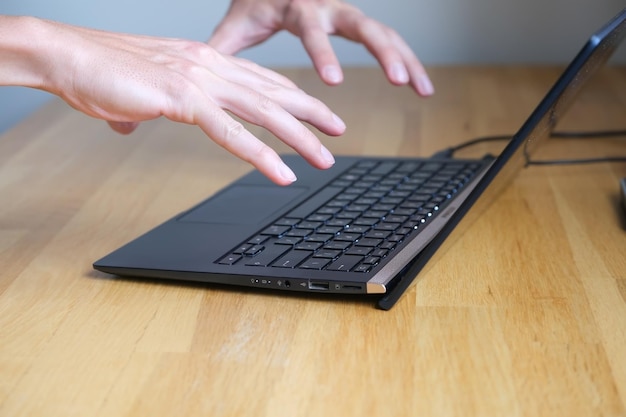 O homem começa a trabalhar em um laptop, mantém as mãos sobre o teclado