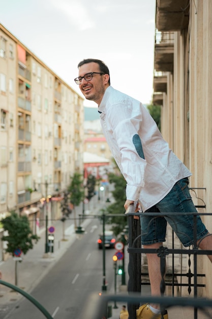 O homem da felicidade sorri e posa em uma varanda