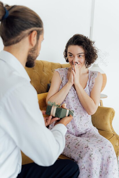 Foto o homem dá um presente à mulher