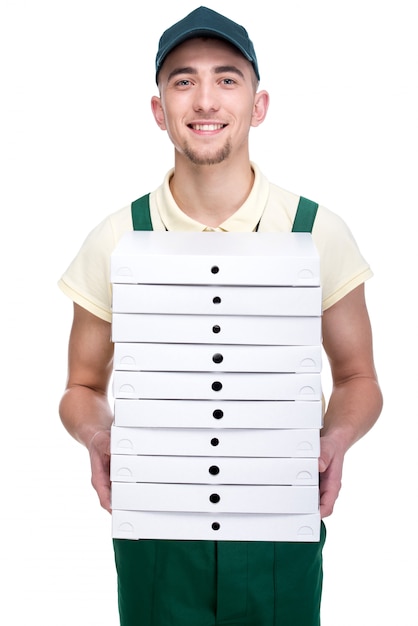 O homem de entrega novo de sorriso está guardando uma pizza.