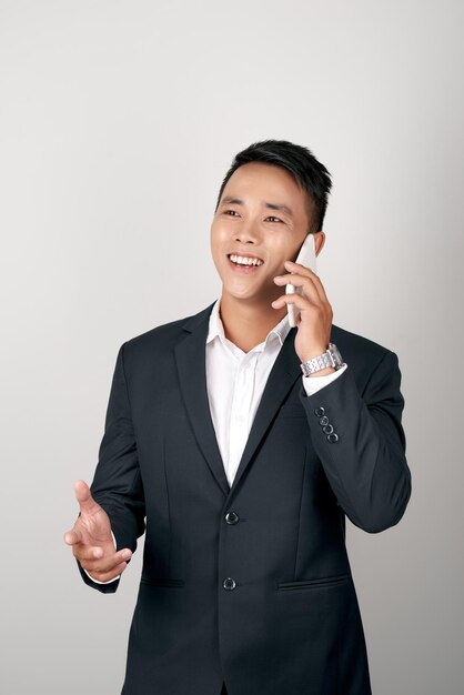 O homem de negócios conversa usando o telefone celular isolado no fundo branco