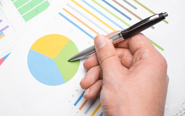 O homem de negócios financeiros analisa o gráfico de desempenho da empresa para gerar lucros e crescimento, relatórios de pesquisa de mercado e estatísticas de receita, conceito financeiro e contábil.