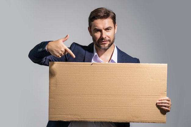 O homem de negócios mantém o cartaz de cartão em branco pronto para o seu homem de produto de terno mostrando boa de sinal em branco