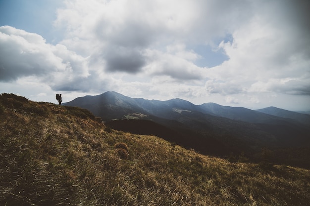 Foto o homem de pé na montanha no fundo da nuvem