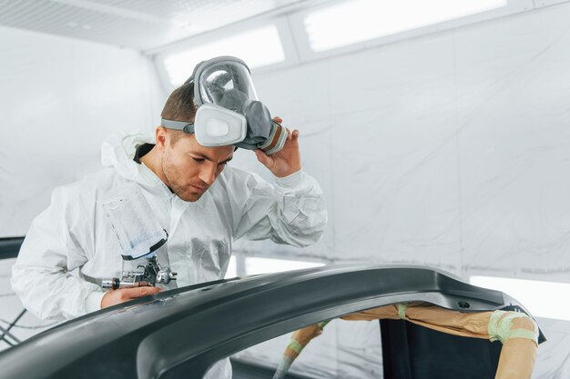 O homem de uniforme está a trabalhar no serviço de automóveis.