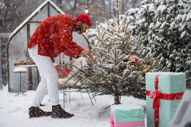 O homem decora a árvore de natal no quintal