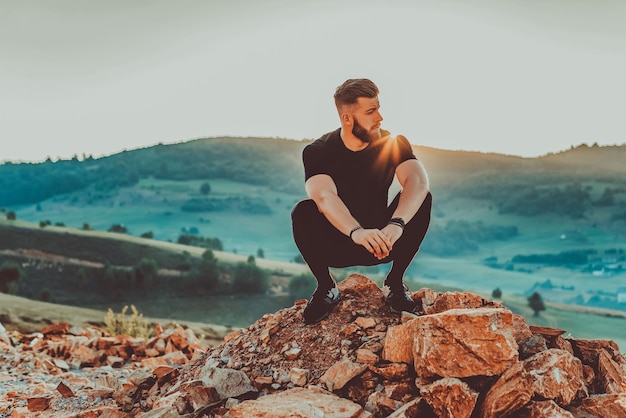 O homem descansa no topo da montanha após o treinamento Conceito de motivação