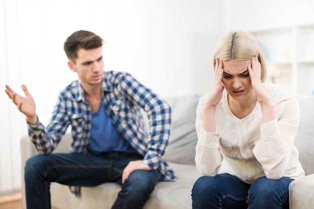 O homem e a mulher brigando no sofá