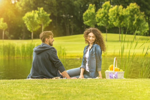 O homem e a mulher descansam no piquenique no parque