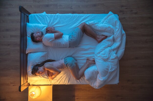 O homem e a mulher dormindo na cama. noite noite. vista de cima