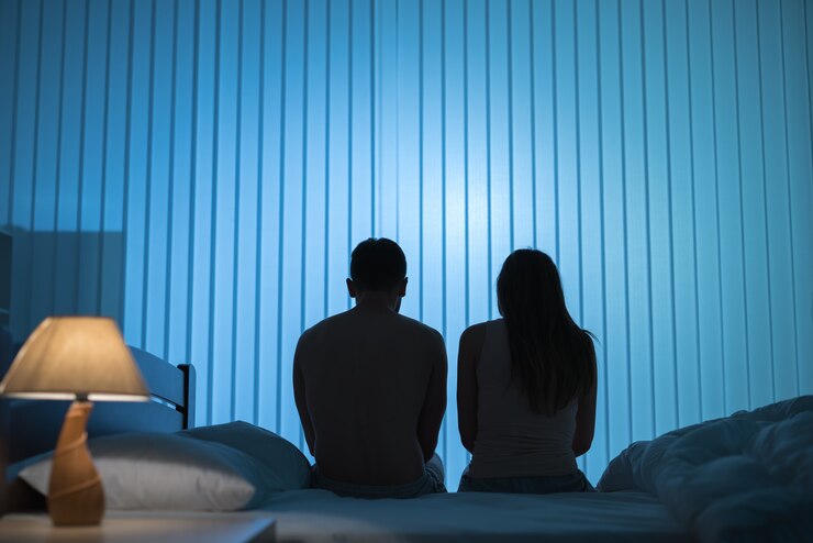 Foto o homem e a mulher estão sentados na cama. período noturno