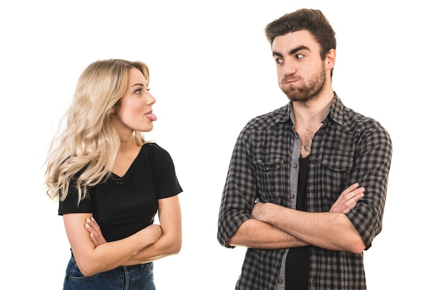 O homem e a mulher fazem careta no fundo branco
