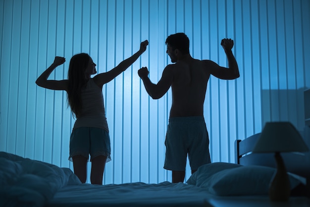 O homem e a mulher fazendo exercícios no quarto. período noturno