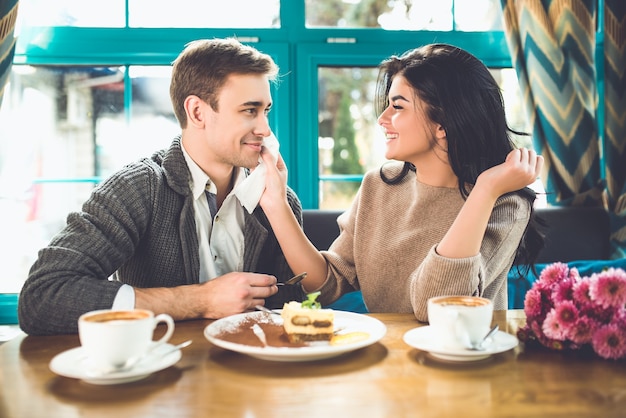 O homem e a mulher felizes têm um encontro romântico em um café