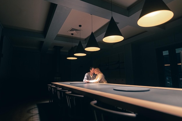 O homem e a mulher namorando no bar noturno vazio