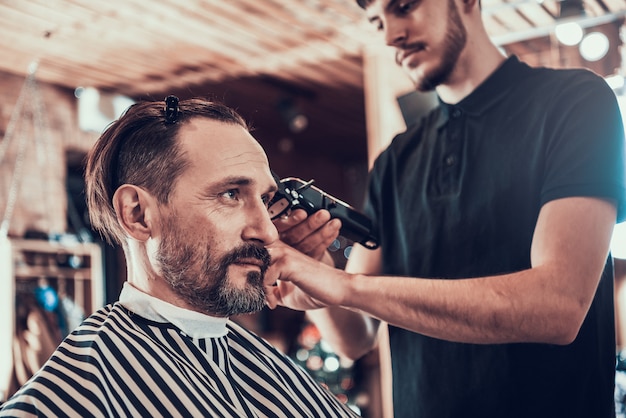 O homem é cortado na barbearia por um mestre profissional.