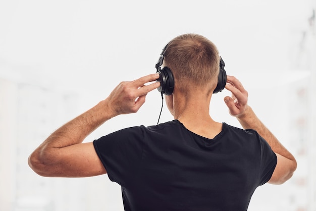 O homem em fones de ouvido no fundo da janela