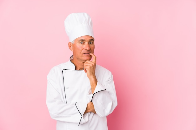 O homem envelhecido médio do cozinheiro isolou o pensamento relaxado sobre algo que olha um espaço da cópia.