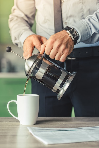 Foto o homem está derramando-se café da manhã em casa