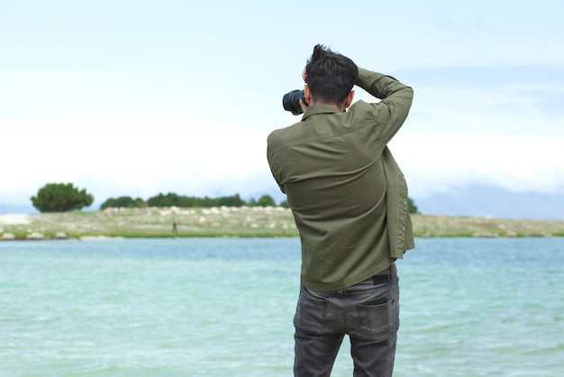 Foto o homem está fotografando o mar