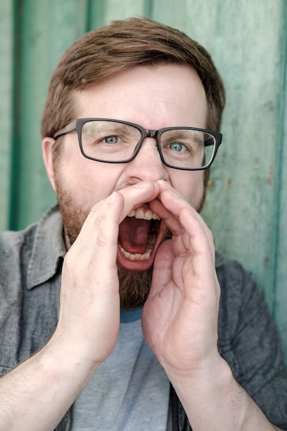 Foto o homem está gritando alto ele está chamando alguém com a boca aberta