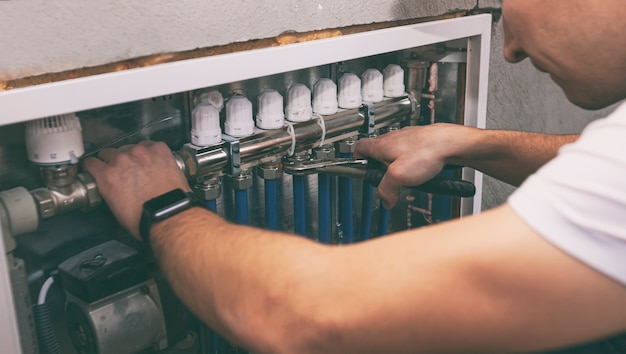 Foto o homem está instalando o sistema de aquecimento na casa