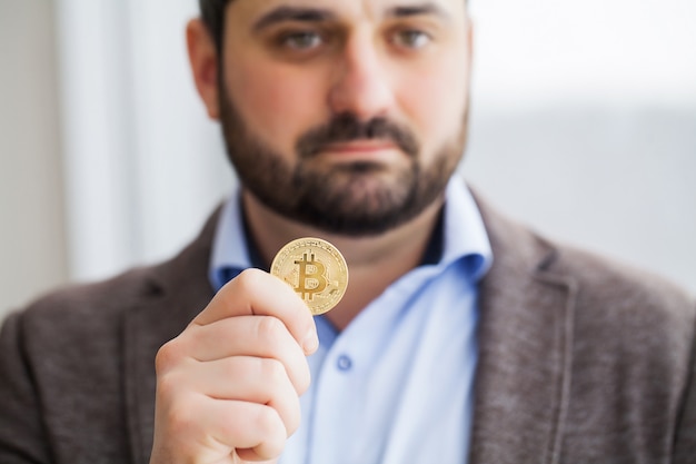 O homem está segurando bitcoins em seu escritório