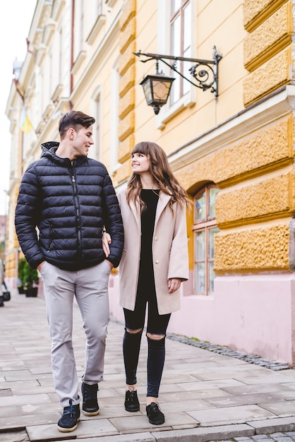 O homem feliz e uma mulher caminhando na rua