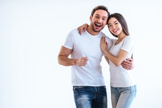 O homem feliz e uma mulher em pé sobre o fundo branco