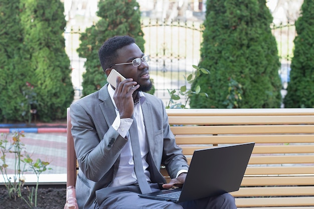 O homem feliz na rua com laptop, freelancer