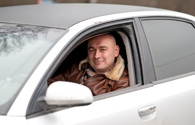 O homem feliz senta no carro