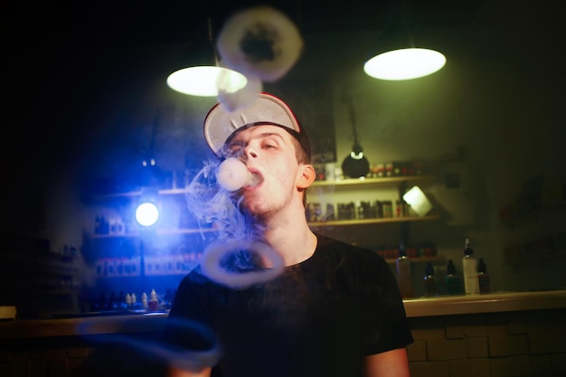 O homem fuma um cigarro eletrônico na loja vape