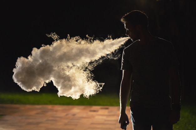 O homem fumando na rua. noite noite