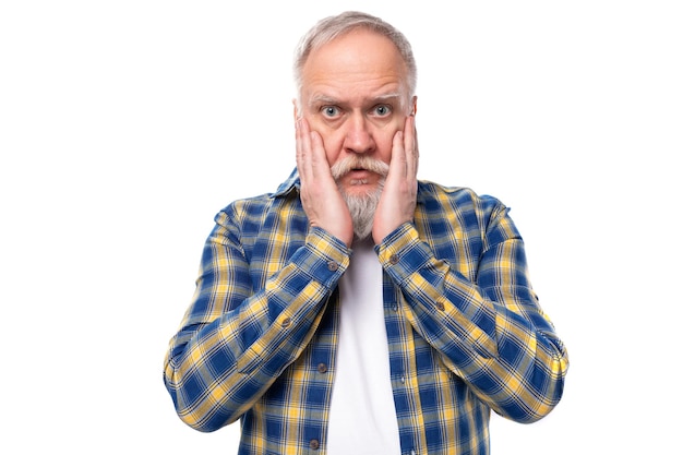 O homem idoso bonito de cabelos grisalhos com barba está pensando em um fundo branco