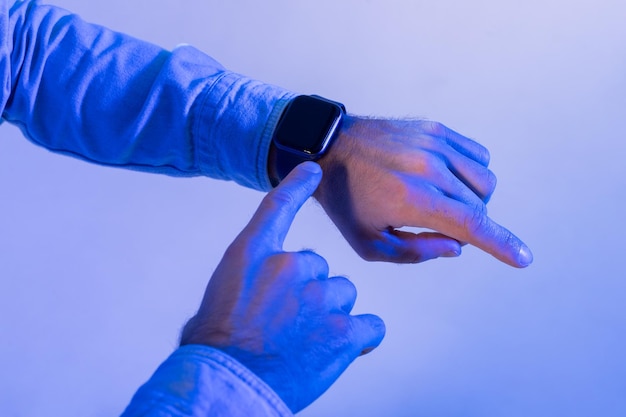 O homem interage com o seu smartwatch usando o dedo para navegar através de notificações ou opções