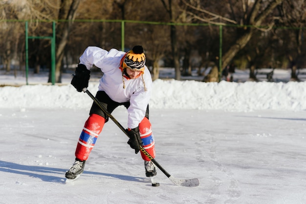 O homem joga hóquei na pista