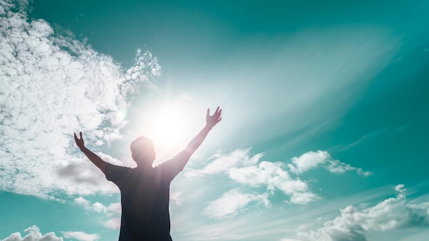 O homem levanta a mão para o incrível céu azul, sente nunca desiste e a liberdade