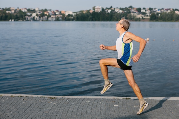 O homem mais velho está empenhado em correr ao ar livre. Foto de alta qualidade