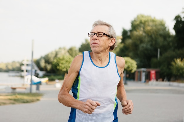 O homem mais velho está empenhado em correr ao ar livre. Foto de alta qualidade