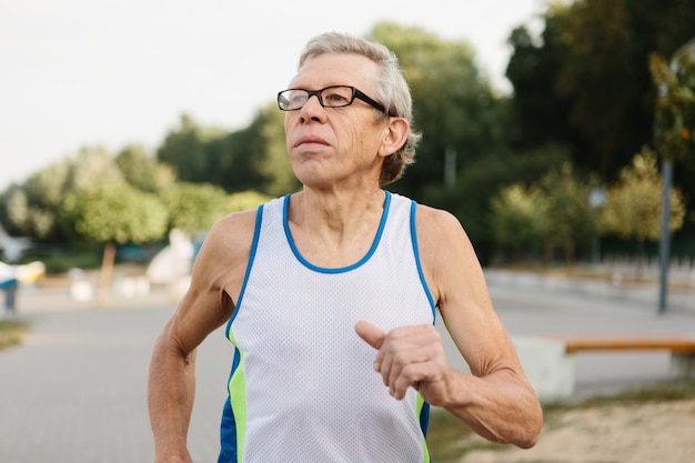 Foto o homem mais velho está empenhado em correr ao ar livre. foto de alta qualidade