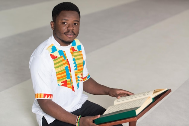 O homem muçulmano africano está lendo o Alcorão