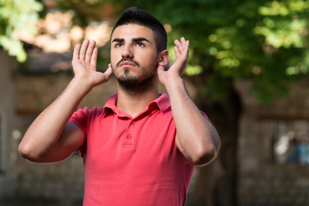 O homem muçulmano está rezando na mesquita ao ar livre