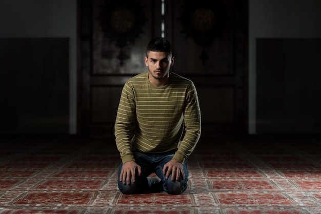 O homem muçulmano está rezando na mesquita