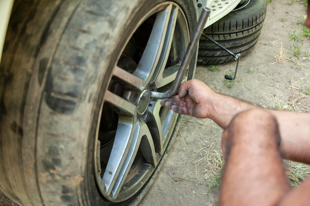 Foto o homem muda o pneu do carro