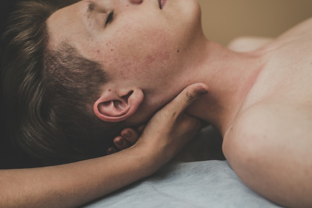 O homem na mesa de massagem é relaxante. O homem antes da massagem se sente calmo e encontra-se em uma toalha