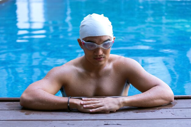 O homem na piscina está nadando para se exercitar.