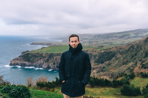 O homem no topo em meio à bela paisagem das rochas e do lago