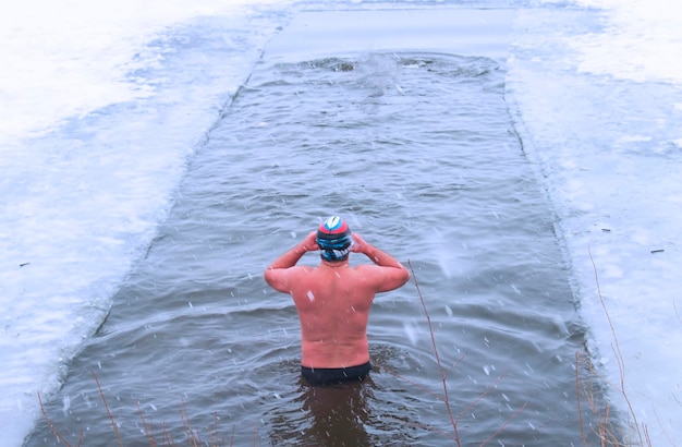 O homem no treinamento de esportes de inverno endurecendo o gelo da neve